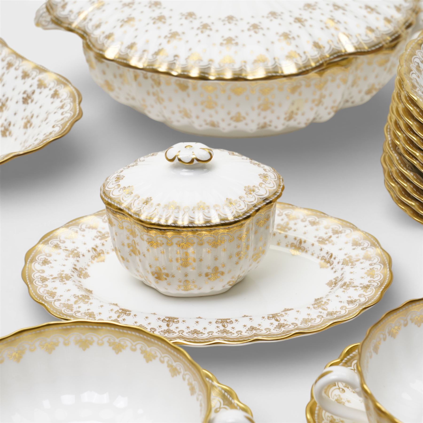 Spode Fleur de Lys tea and dinner service for ten, comprising dinner plates, side plates of graduating sizes, bowls, twin handled soup bowls, three covered dishes, sauce boat and saucer, two serving dishes, open serving dish, teapot, coffee pot, milk jug, covered sucrier, cake plate, vase, jardiniere, cups and saucers
