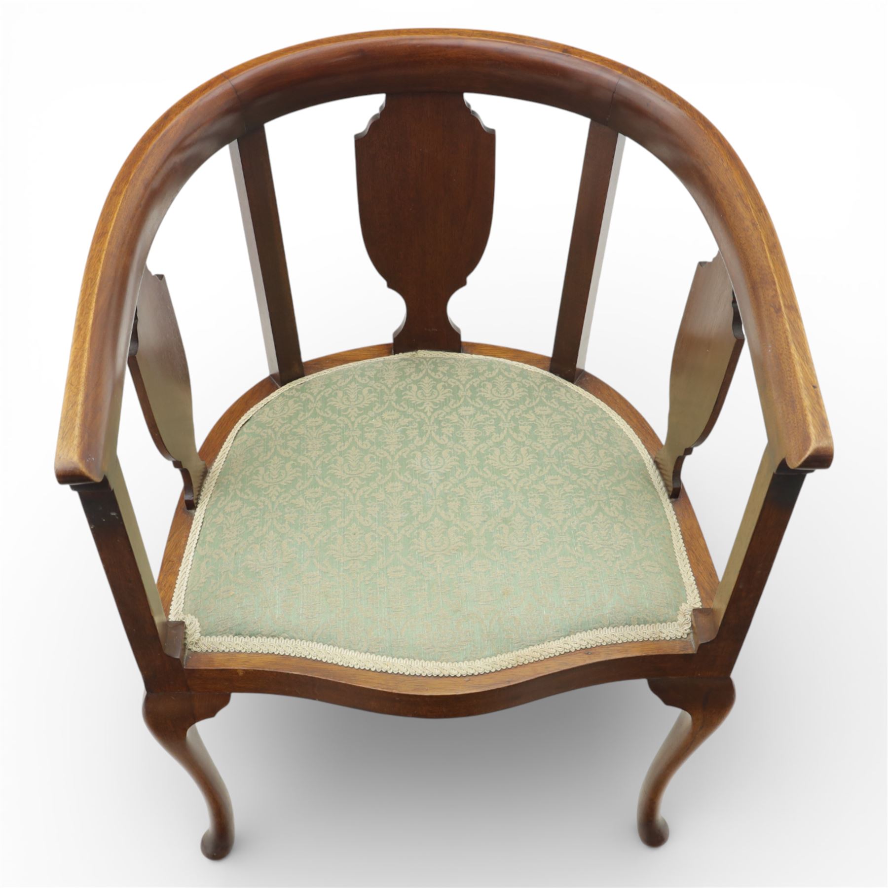 20th century mahogany tub chairs, the arched backs enclosing shaped splat panels and plain uprights, open curved arms flowing into the seat rails, upholstered seats in green foliate patterned fabric, on cabriole legs