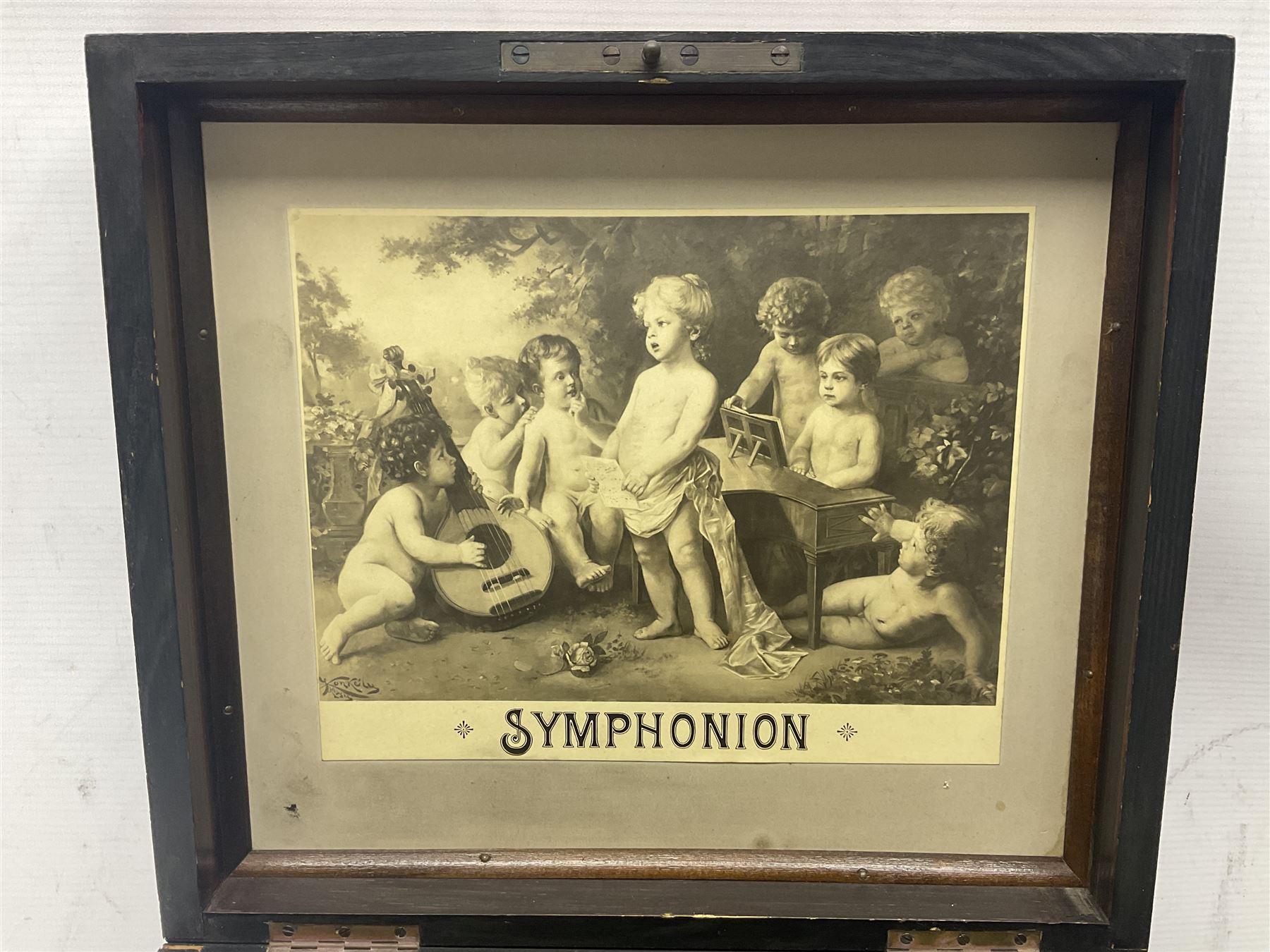 Late 19th century Symphonion disc musical box for spares or repair, inlaid walnut case with front lever action, playing 25.5cm discs on a 10.5cm steel comb with forty-nine teeth, musical scene of cherubs under the lid, L33cm; together with twelve 25.5cm discs