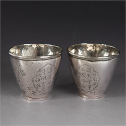 Pair of Chinese export silver teacups, both decorated with character marks, one with floral decoration, the other decorated with a bird within bamboo branches, both with indistinct maker's marks beneath, H6cm