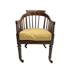 William IV rosewood tub armchair, the arched bow cresting rail over graduated bobbin turned spindles, cane seat with loose cushion, terminating in brass cups and castors.