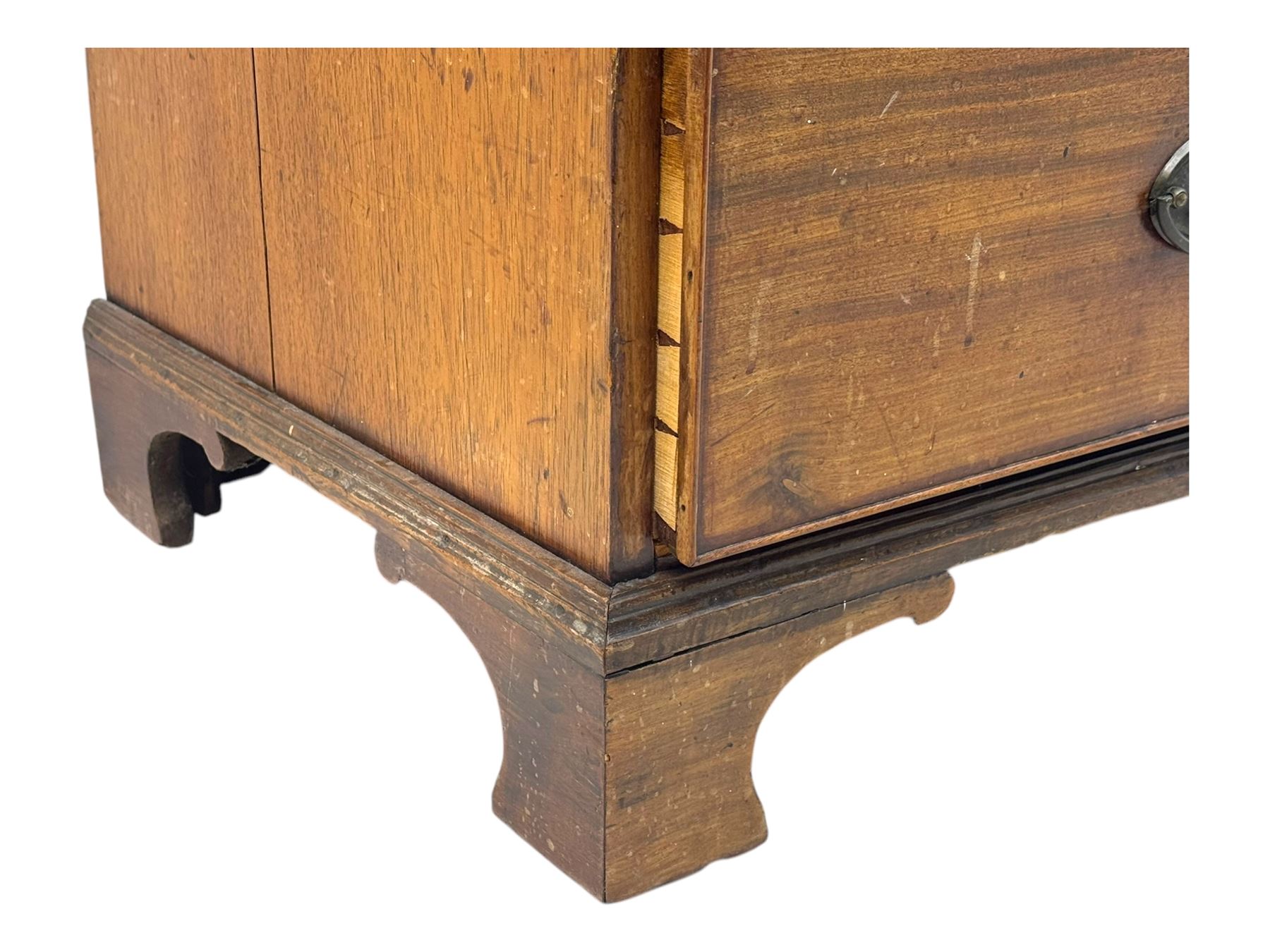 Early 19th century mahogany linen press cupboard, projecting moulded cornice over figured frieze, two panelled doors enclosing shelves, fitted with two short and two long cock-beaded drawers, on bracket feet 