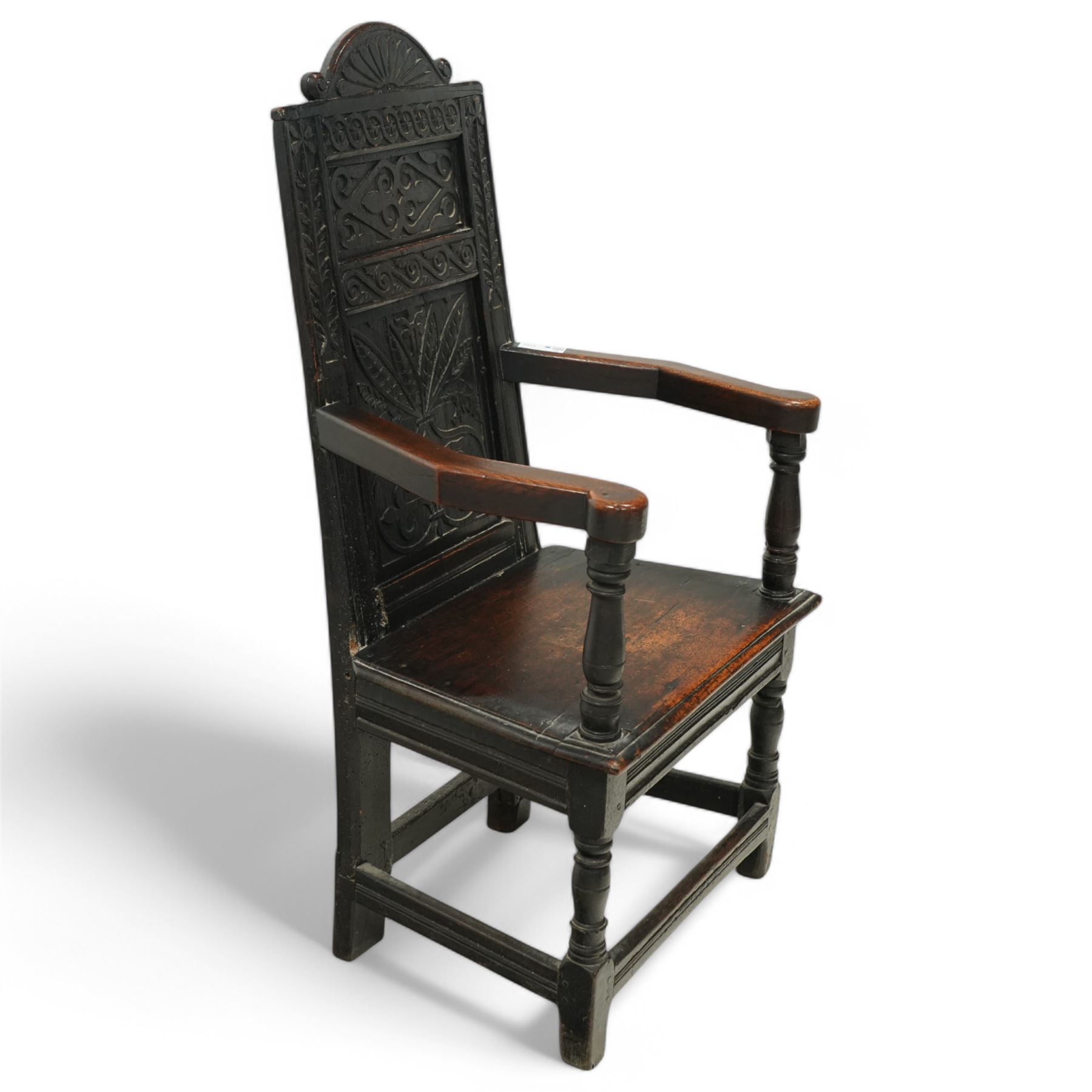 17th century and later carved oak Wainscot chair, the panelled back decorated with carved foliage and scrolls, the frame decorated with trailing guilloche and foliate motifs, moulded seat over turned supports united by stretchers 