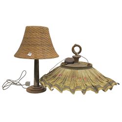 Trench Art shell lamp upon a stepped circular base, together light fitting with an umbrella shade depicting a hunting scene and a wicker lamp shade