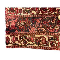 Two Persian crimson ground rugs, decorated with floral and foliate motifs max 137cm x 82cm (2)