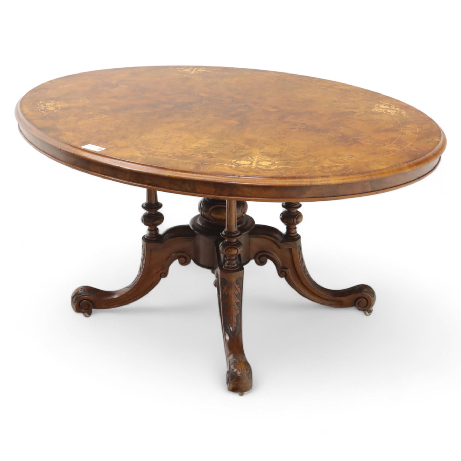 Victorian inlaid burr-walnut and marquetry oval centre table, quarter veneered tilt-top with scrolling foliate and floral marquetry reserves on a turned carved column with clustered supports raised on four out-swept scroll legs on ceramic castors  