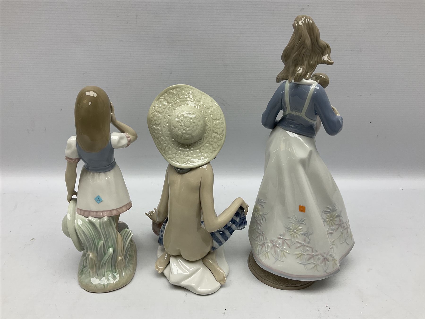 Three Lladro figures, comprising Modern Mother no 5873, Dropping the Flowers no 1285 and On the Beach no 1481, all with original boxes, largest example H30cm