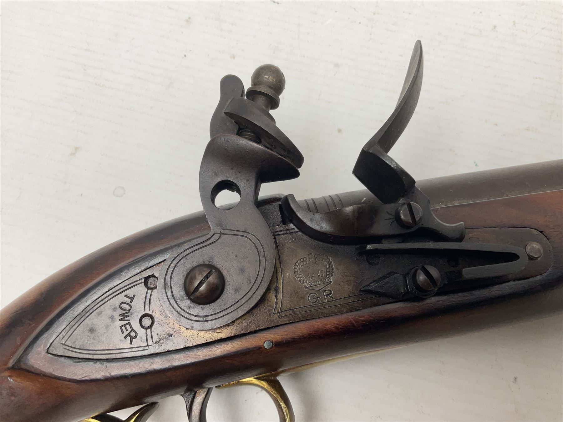 Modern non-firing reproduction Tower flintlock pistol marked with crowned GR and Tower to the lock, brass skull crusher butt and fittings L40cm overall; another Indian/Moorish reproduction flintlock pistol with mother-of-pearl inlay; and a modern die-cast replica Colt style revolver (3)