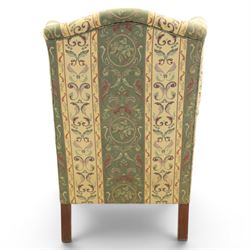 Queen Anne style wingback armchair, upholstered in green and cream foliate fabric, shaped arms on ball and claw feet
