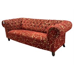Late 20th century upholstered Chesterfield sofa, in red damask floral fabric, with deep buttoned back and arms, scrolled arms at equal height to back, on turned front supports