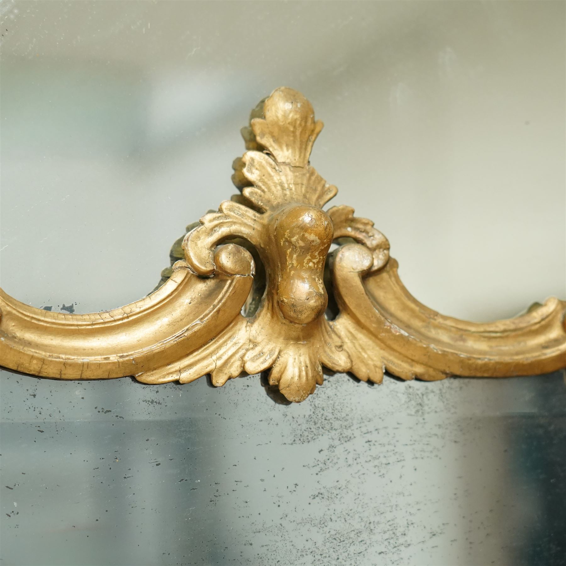 George III Chippendale design carved giltwood and gesso wall mirror, the impressive protruding pierced pediment decorated with flared acanthus leaves interspersed with flower heads and berries, over an arched outer-frame - the cresting comprised of C-scrolls carved with dripping icicle motifs, the uprights formed of scrolling acanthus with swags of grapevines and foliage, over a scrolled cartouche terminal, the inner-frame of architectural form with bell-flower details and a shaped cresting with scrolling acanthus leaves, all enclosing a central slightly bevelled rectangular mercury glass plate, surrounded by smaller plates