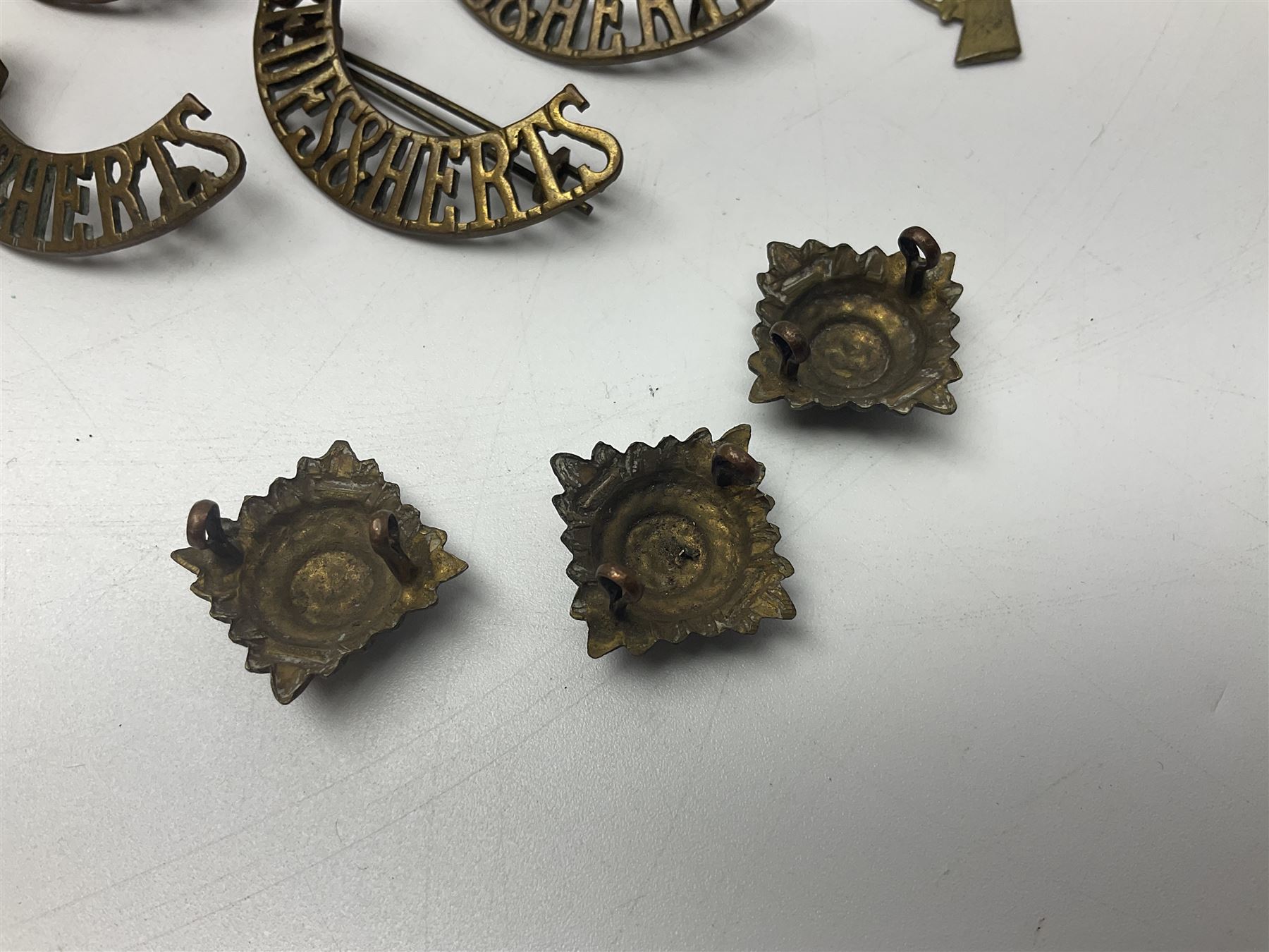 Over thirty British and Continental military metal badges; together with quantity of shoulder titles, collar dogs, rank pips, uniform buttons etc