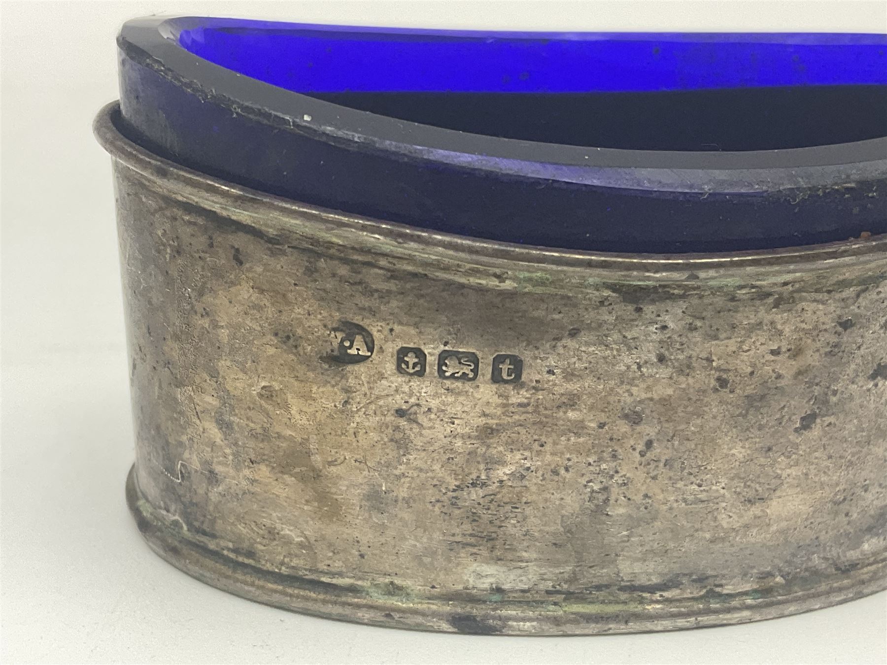 Modern two piece silver cruet set, comprising pepper shaker and open salt, each with shaped rims and upon four pad feet, hallmarked William Suckling Ltd, Birmingham 1962, together with an early 20th century silver open salt, of oval form, hallmarked William Aitken, Birmingham 1918