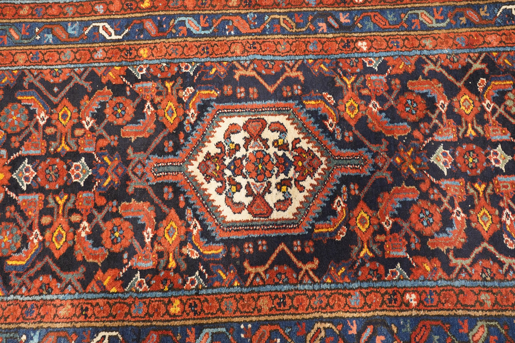 Large vintage Persian Hamadan indigo ground runner rug, the busy field with central ivory medallion and spandrels, surrounded with Herati motifs and stylised plant symbols, with multiple floral decorated guard bands
