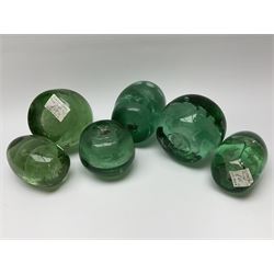 Six Victorian green glass dump paperweights, with internal foil flower decoration. 