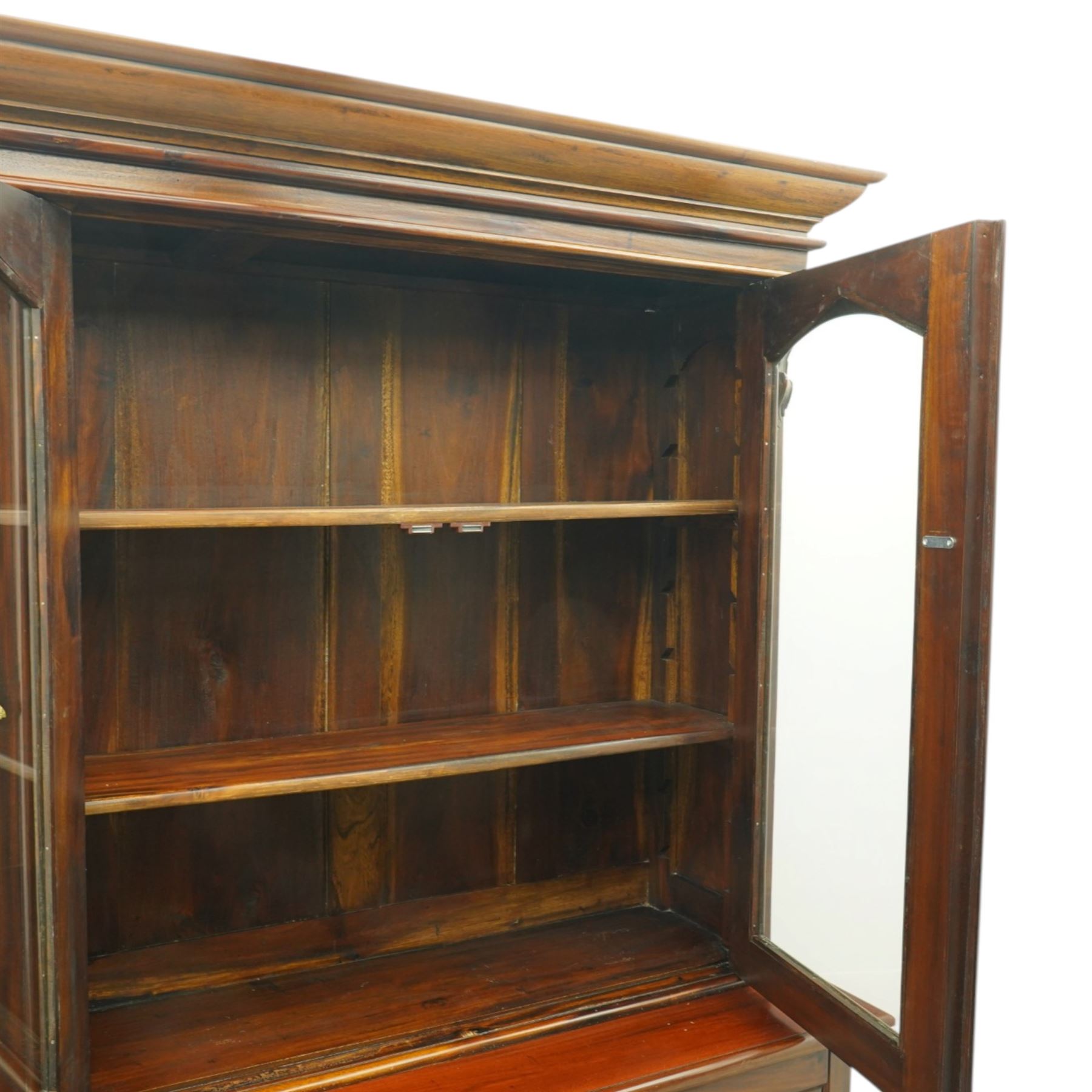 Victorian revival hardwood dresser cabinet, projecting moulded cornice above three glazed doors with shaped tops enclosing shelves, moulded top over three drawers and three panelled cupboard doors, flanked by applied carved brackets, on plinth base
