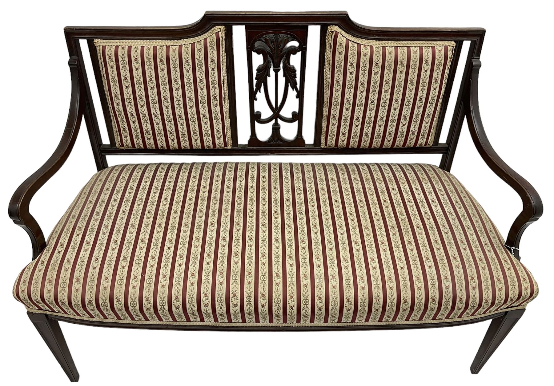Edwardian mahogany framed three-piece salon suite - two-seat sofa, stepped cresting rail over acanthus and scroll carved pierced splat, upholstered in striped fabric (W124cm, H87cm, D62cm); and a pair of matching armchairs (W60cm) 