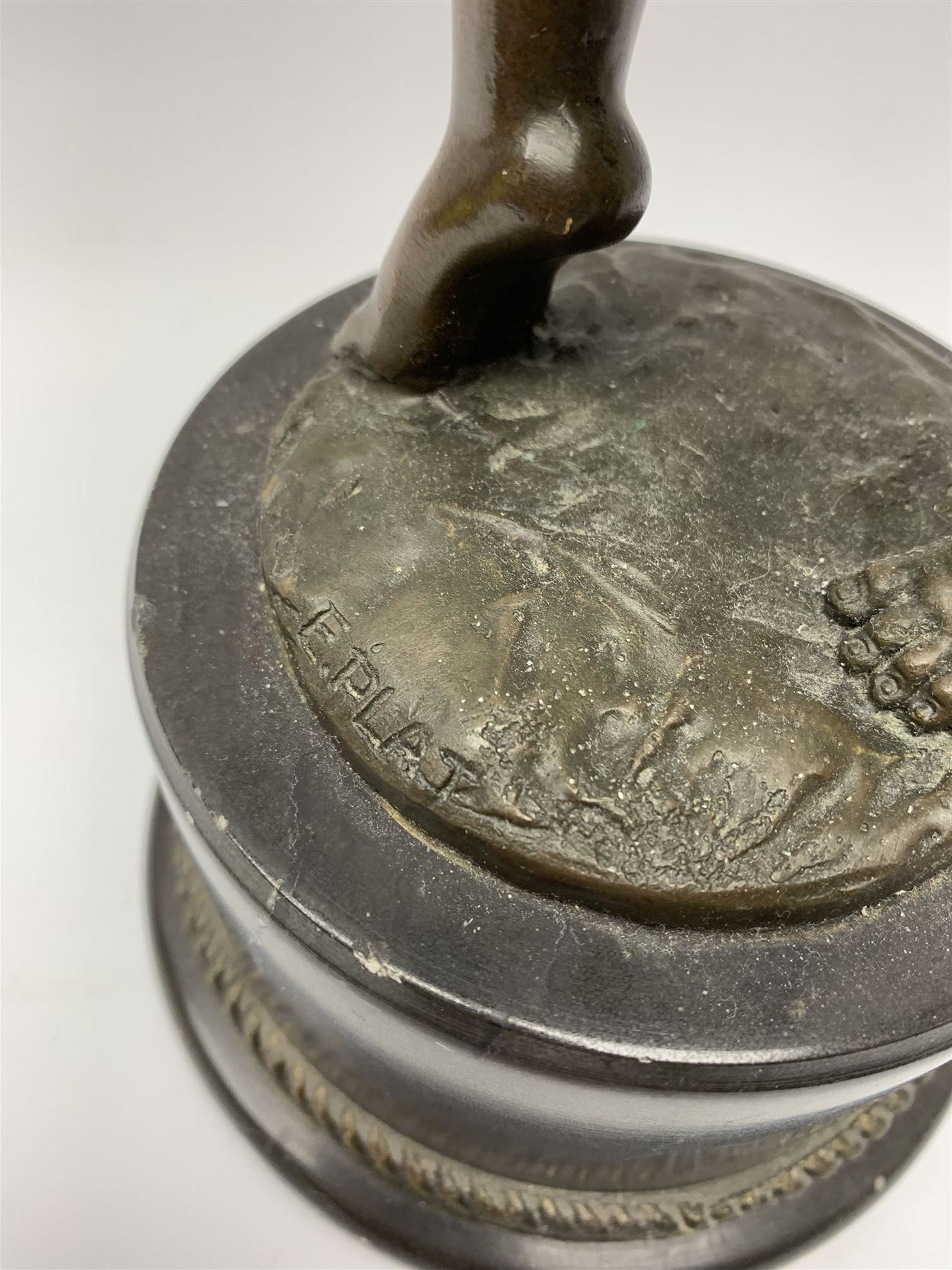 After E Plat, bronze modelled as a dancing child, signed E. Plat, upon cylindrical black marble base, H40cm