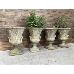 Set of four Victorian design cast stone Grecian urns, tapering form cast with figures and handles, square plinth bases