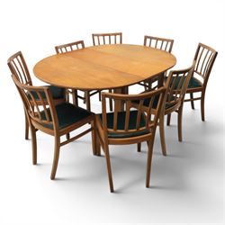 Mid 20th century teak extending dining table, together with eight teak chairs with green leather seats, extends to 154cm
