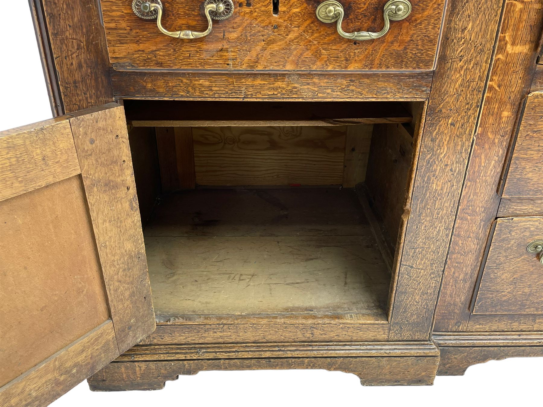 George III oak dresser, projecting dentil cornice over three heights plate rack enclosed by fluted uprights, the dresser fitted with five drawers and two panelled cupboards, canted corners with fluted quarter columns, on bracket feet