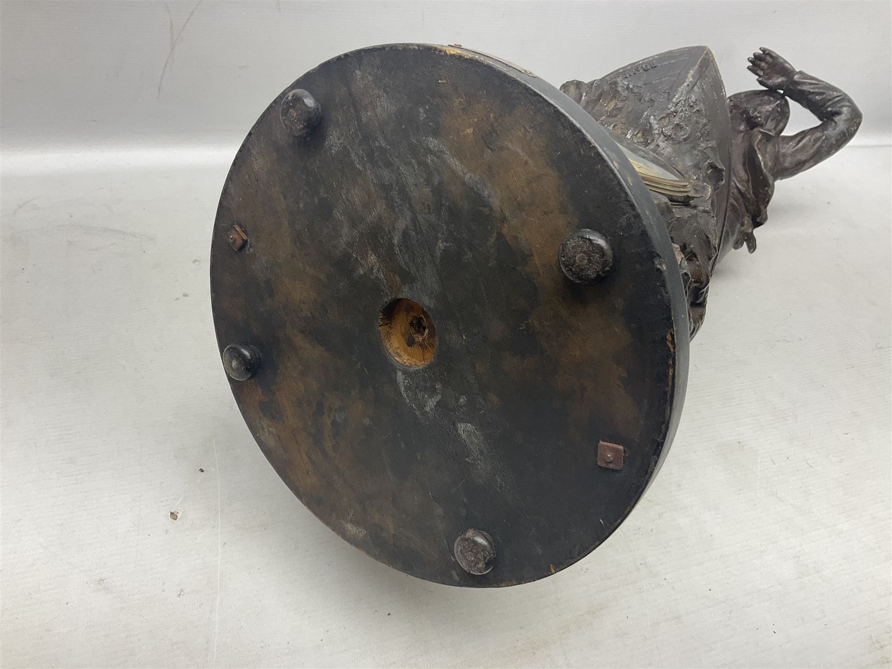 Early 20th century spelter effect figure of a sailor standing in the bow of a boat scanning the horizon, on a simulated rock base with a plaque entitled 'Rescue', base fitted with a timepiece clock movement and two-part dial, with pierced hands, gilt dial centre and ivorene chapter ring written in Arabic numerals, German HAC spring driven going barrel movement wound from the front; with pendulum H65.5cm
