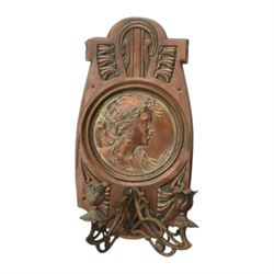 Pair of late 19th/early 20th century Art Nouveau copper twin branch wall sconces, each with shaped back plate chased with a central panel of a maiden in profile above and surmounted by foliate motifs, supporting two foliate open cast branches with bud sockets above conforming drip pans, H31cm W16cm D8.5cm
