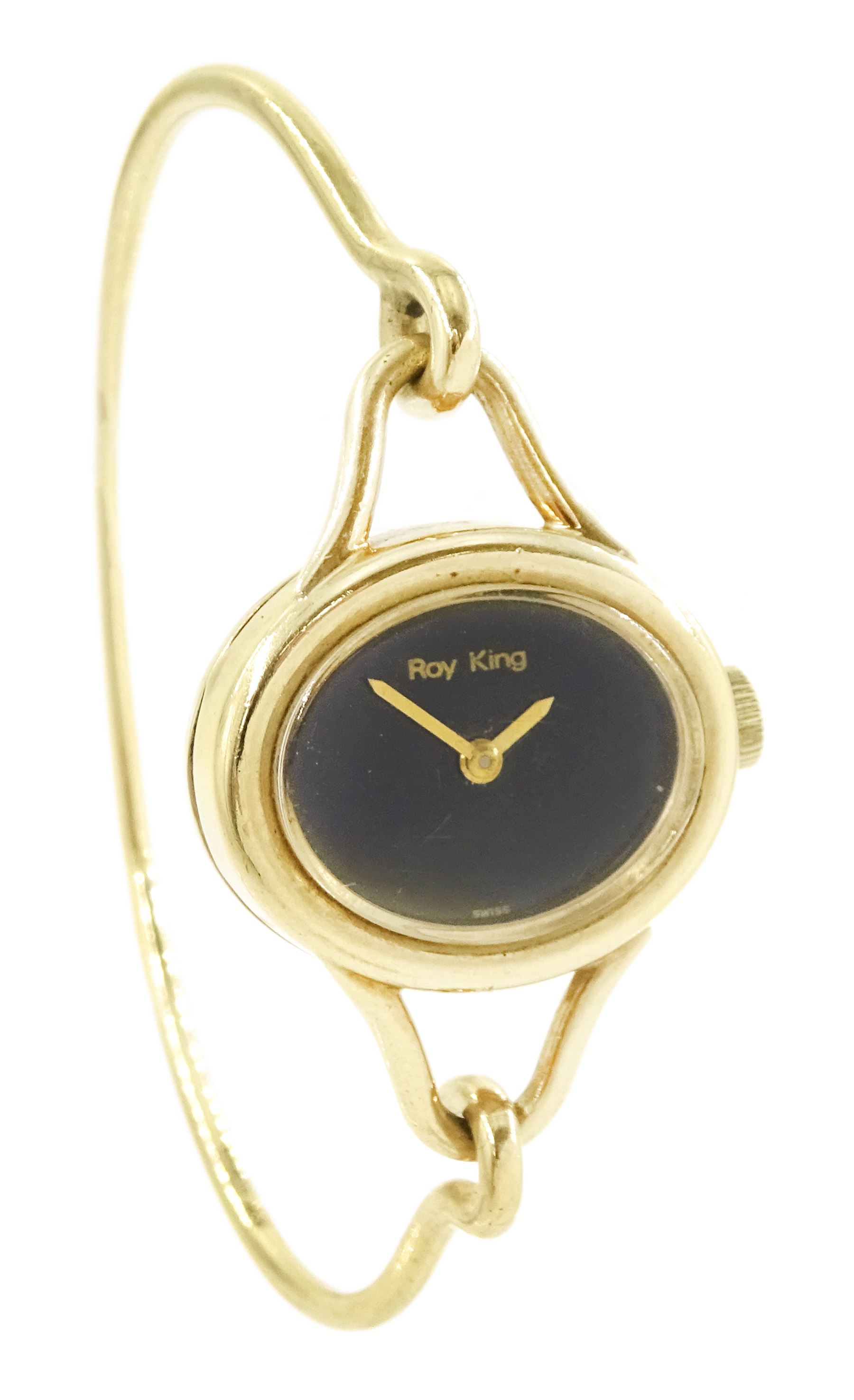 Roy King ladies 9ct gold manual wind wristwatch, black oval dial, on 9ct gold bangle, London 1978