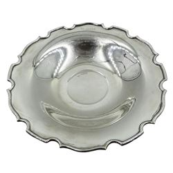 Early 20th century Indian colonial silver footed dish, of circular form with castellated rim and engraved personal inscription, upon a spreading circular foot, marked for Warner Brothers, D25cm, approximate weight 13.56 ozt (422 grams)