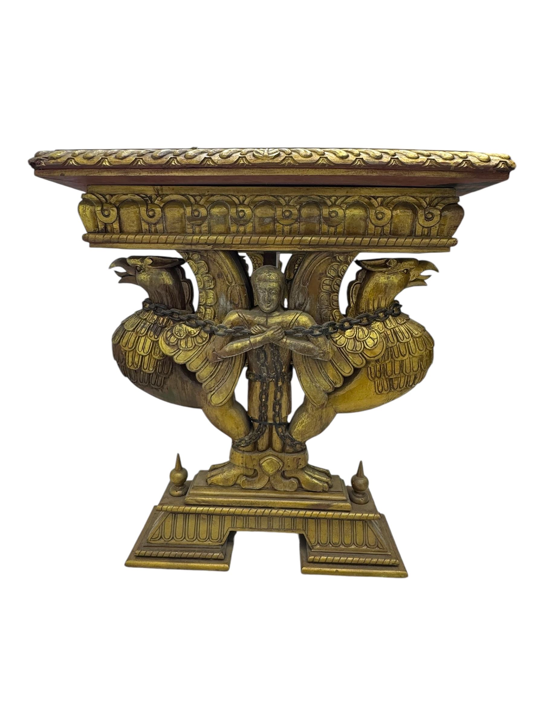 19th century Renaissance Revival carved and giltwood centre table, the rectangular top with gadrooned edge and carved frieze of repeating arched motifs with stylised scrolls, supported by a pair of carved winged griffin supports restrained by a central chained figure, on stepped rectangular bases united by carved stretcher