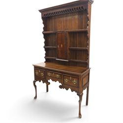 Late 19th century inlaid oak dresser and plate rack, plate rack with projecting cornice and fretwork, with three shaped shelves for plates, central cupboard with inlaid shell and border, brass escutcheon and key, the lower section with crossabanded top, above three drawers with brass handles and inlaid border, shaped apron raised on cabriole supports 