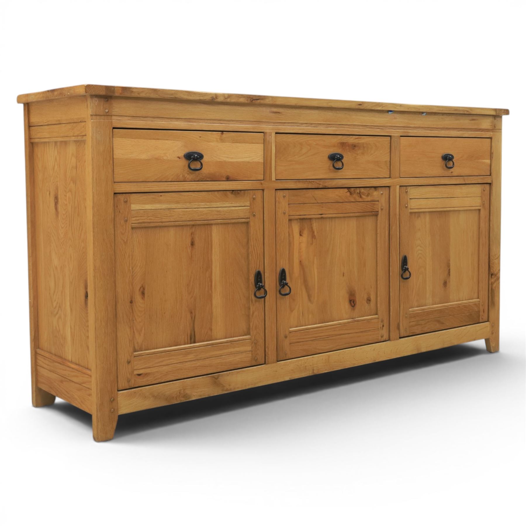 Contemporary oak sideboard, with rectangular top above three drawers and three cupboard doors, blackened metal handles, raised on stile supports