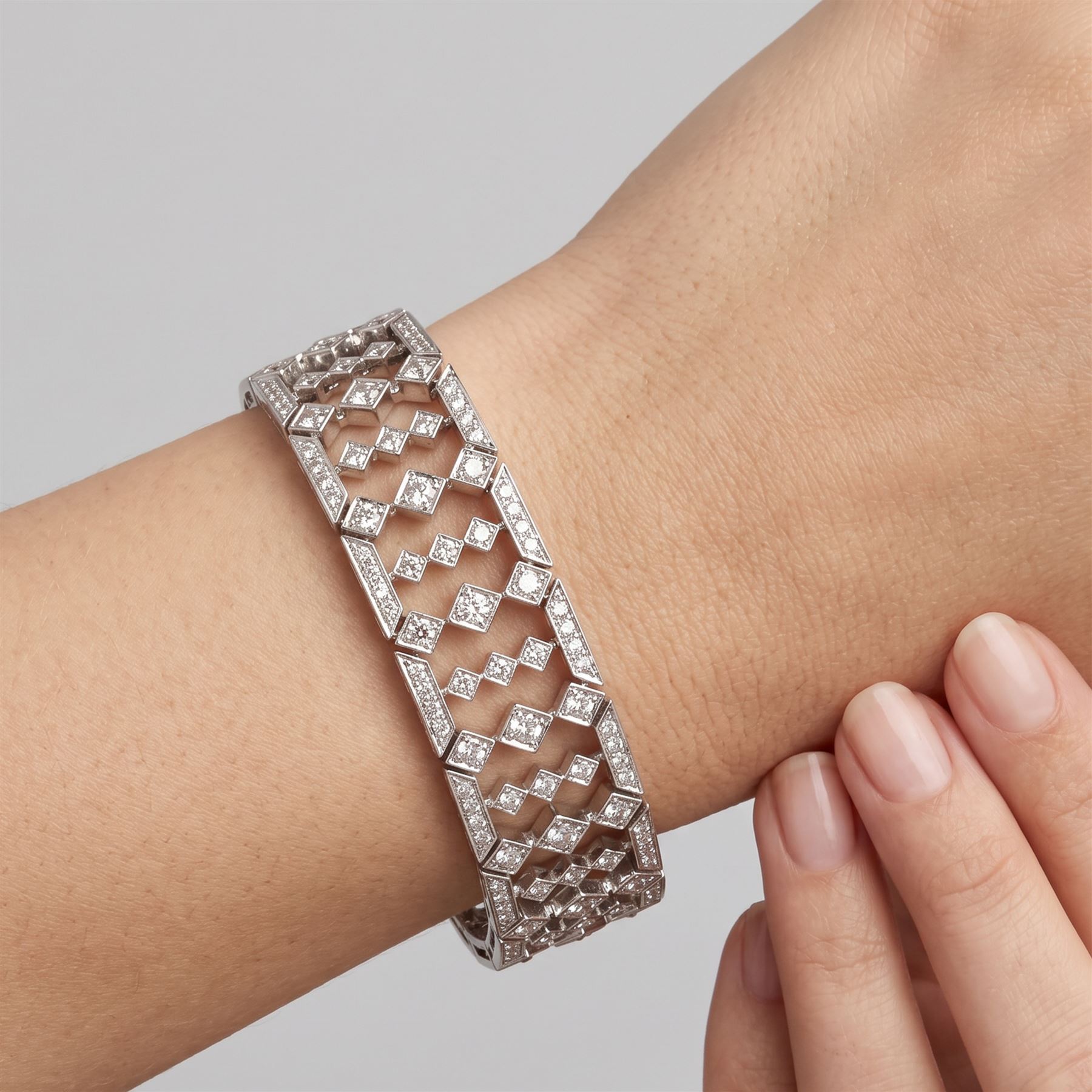 18ct white gold diamond bracelet, articulated and pierced design milgrain links set with round brilliant cut diamonds, the sides with engraved foliate decoration, stamped 750, total diamond weight approx 4.15 carat