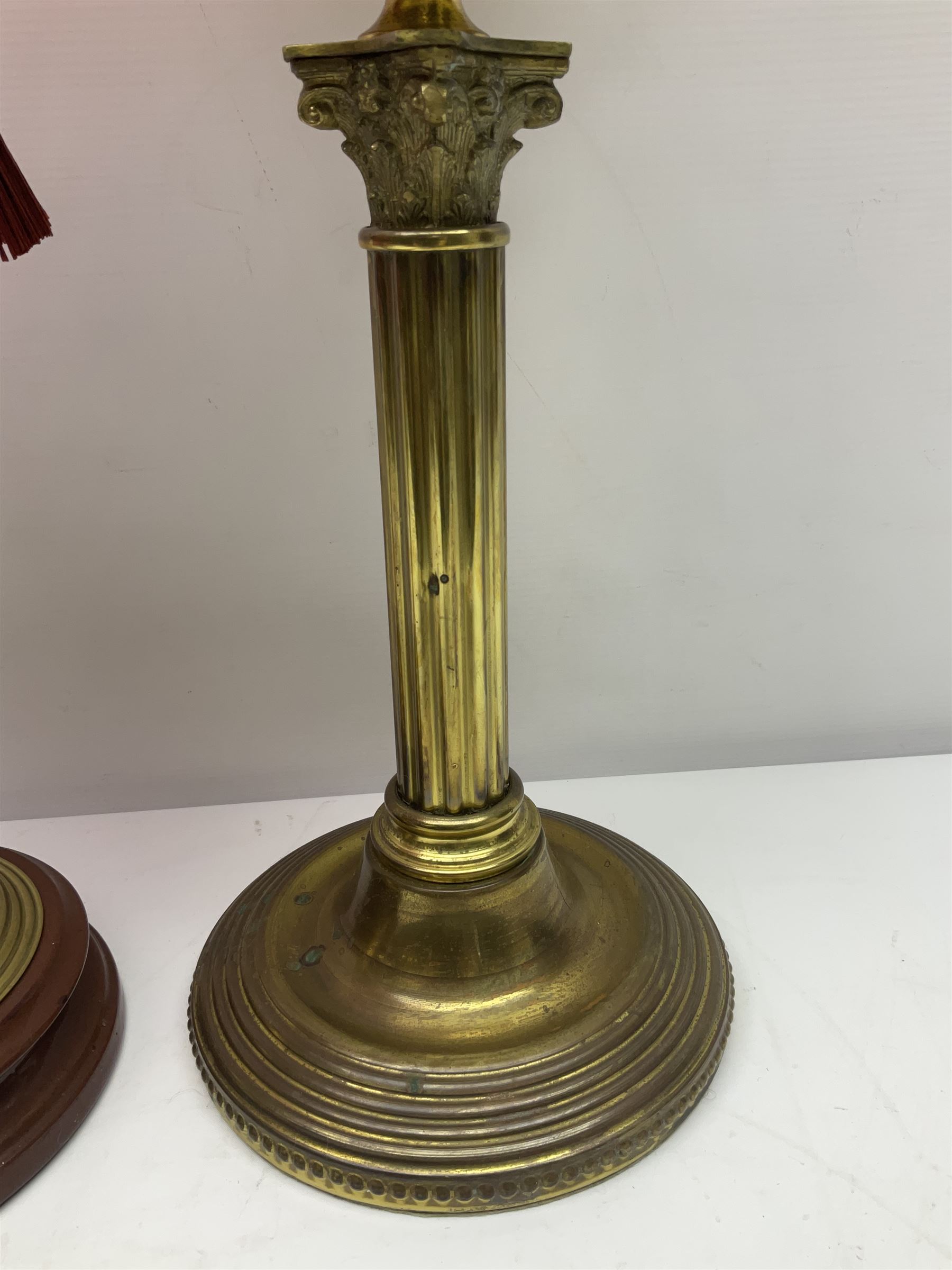 Victorian cast brass oil lamp, with fluted pink glass shade, together with two smaller brass oil lamps with pink shades and reservoirs and a pair of oil lamps, the bases modelled as putti, with pink glass reservoir  and frosted shades, tallest H70cm