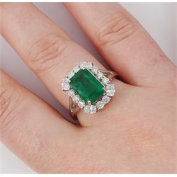 18ct white gold emerald and diamond cluster ring, single octagonal cut emerald of approx 2.90 carat, surrounded by twelve round brilliant cut diamonds and four oval cut diamonds to each corner, stamped 18K, total diamond weight approx 0.90 carat