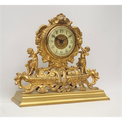  Late 19th century gilt metal mantel clock, ornate cartouche shaped with putto figures, floral and trailing foliage decoration on stepped rectangular plinth, W29cm  