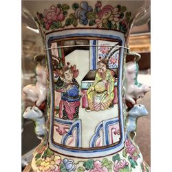Large pair of 19th century Cantonese famille rose vases, each painted with various courtly scenes, including a display of warriors fighting on horseback before an official and his attendants, double Buddhist lion handles and applied at the shoulders with chilong, the lower band painted with Greek key motif, H58cm (2)