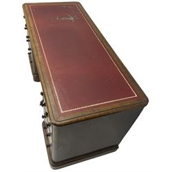 Victorian figured walnut kneehole desk, moulded rectangular top with inset leather writing surface, fitted with nine drawers, the central frieze drawer with carved curled foliage mount, on moulded plinth base,