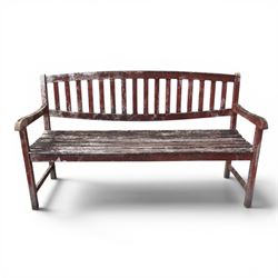 Teak garden bench, with slatted seat and spindle back, shaped armrests, finished in weathered red painted finish.