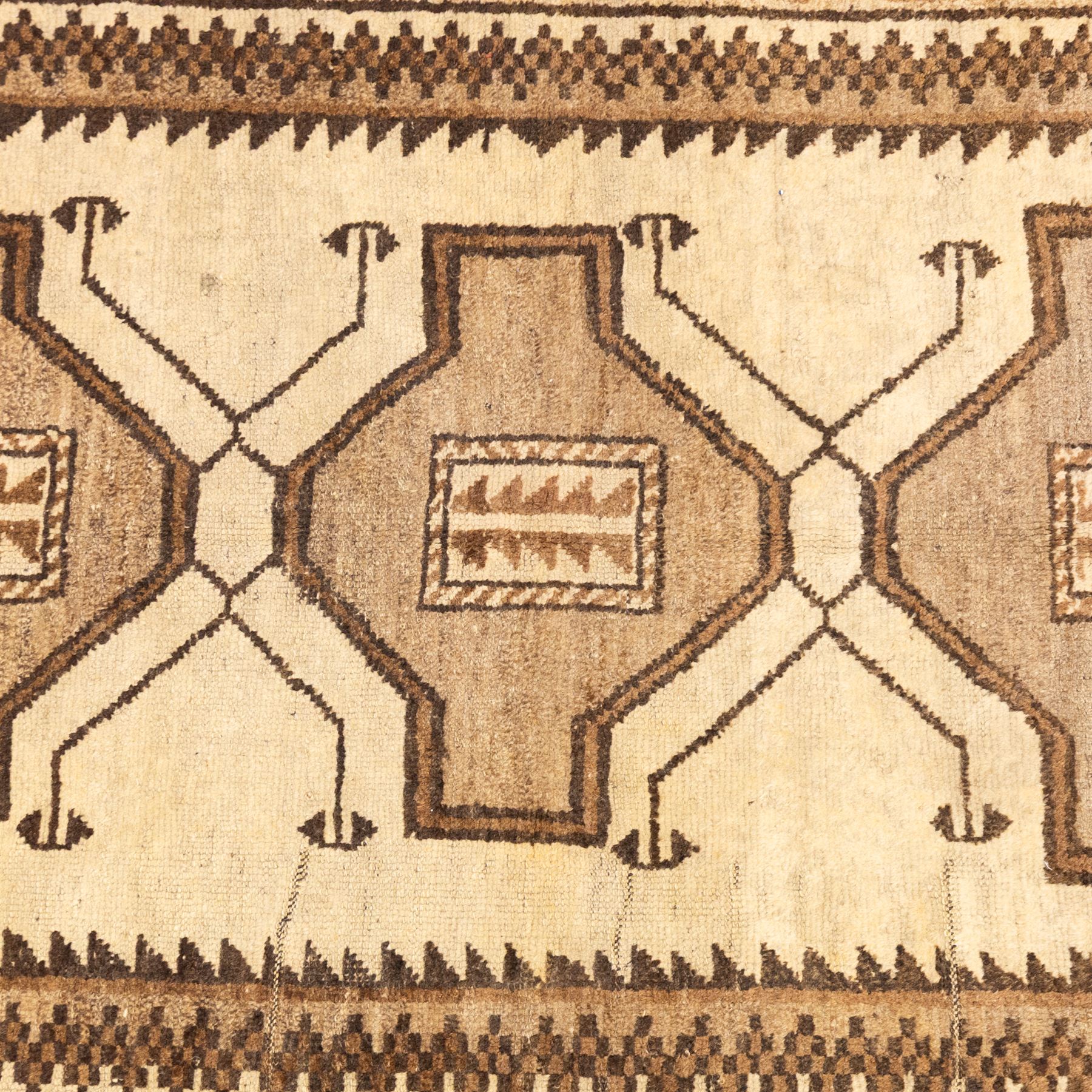 North West Persian Gabeh hand-knotted rug, natural ivory field with a vertical sequence of three large stepped geometric medallions in soft shades of brown and taupe, each enclosing stylized tribal motifs, flanked by narrow guard borders incorporating chevron and zigzag designs, with fringe ends 