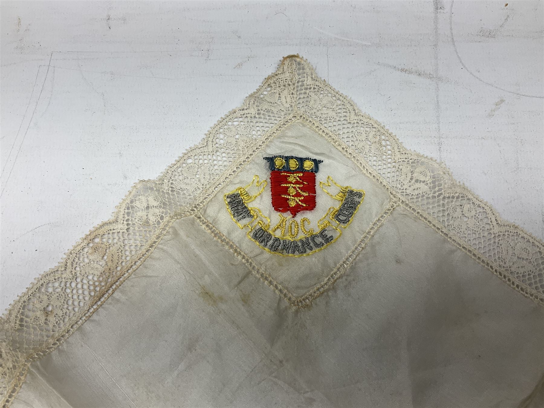 Three WW1 embroidered silk handkerchiefs including RAF & RN; trench art brass napkin ring inscribed 'Arras' and miniature peaked cap with inset 1914 penny; small quantity of cap badges and pips; four reference books on medals and badges etc