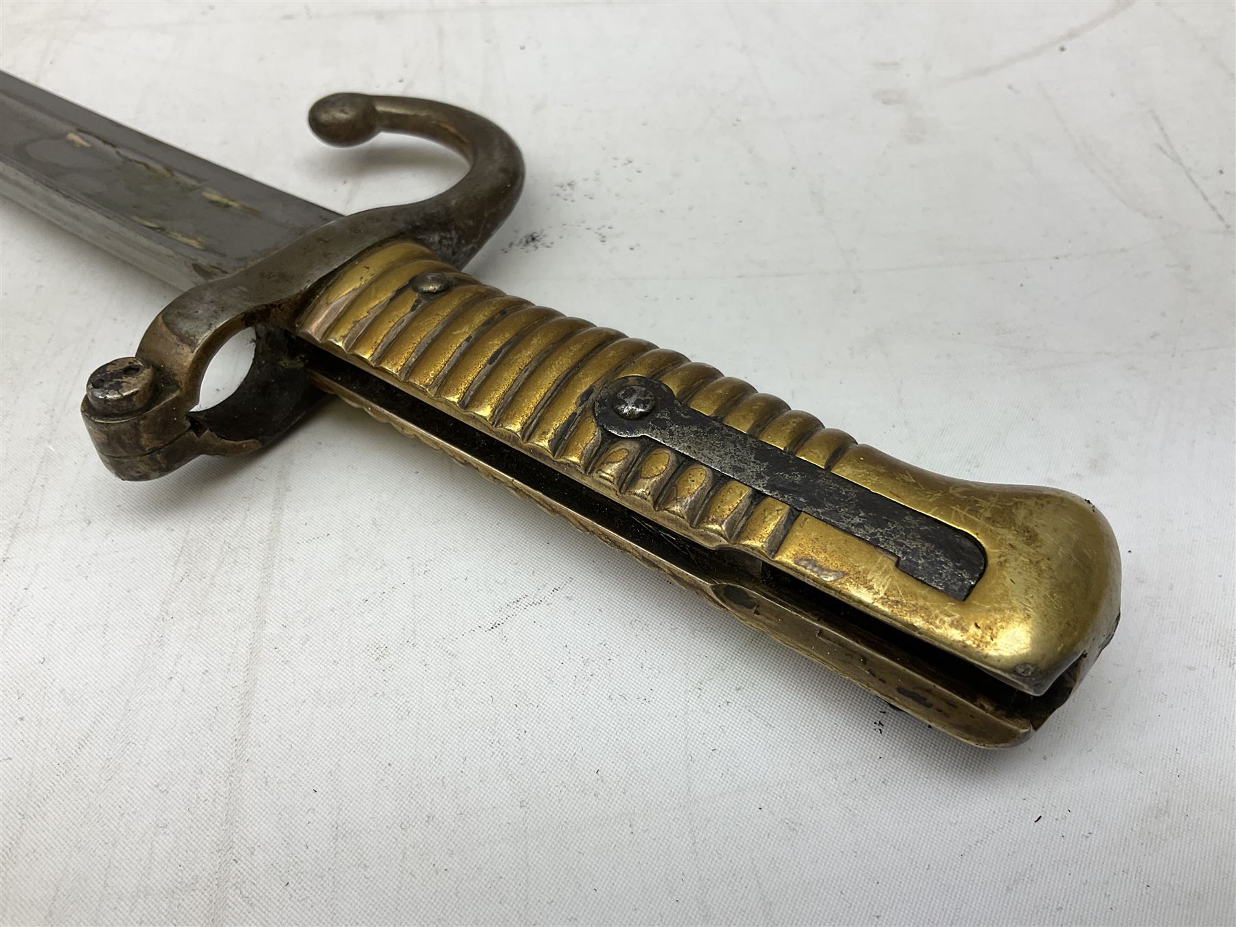 French Model 1866 sabre bayonet with 57cm fullered steel curving blade; in steel scabbard L71cm overall; another Model 1866 sabre bayonet lacking scabbard; and British Pattern 1856 sword bayonet (no scabbard) (3)