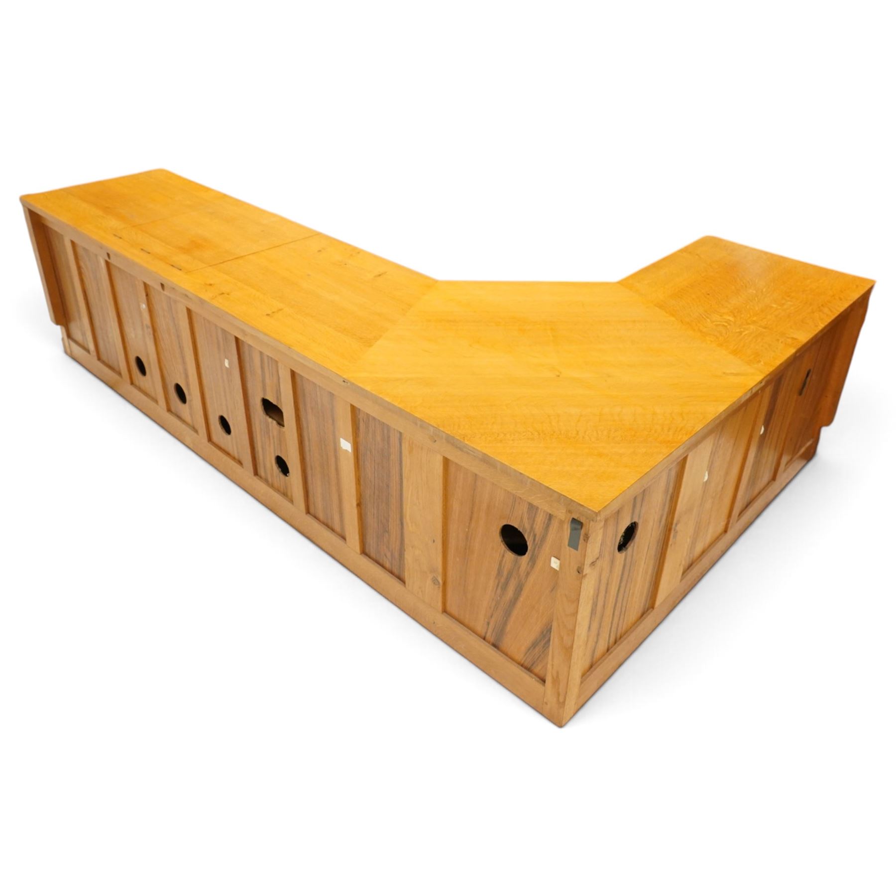 Seahorseman by Shaw & Riley - bespoke large Yorkshire oak corner sideboard or media unit, of L-shape form, with three cupboard doors, a fall front drawer over a regular drawer, a lift up panel for a record player, multiple apertures for wires, raised on a plinth base, with signature Seahorse carving from the workshop of A. Shaw & Riley Ltd, Hessay
