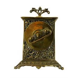Small bedside table clock in a pierced brass case on a splayed plinth, with a 30hr spring wound movement with a balance escapement made by the British United Clock Company, c1920, with an enamel chapter ring and decorative gilt centre, movement wound and set from the rear.