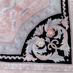 Large late 20th century Aubusson style wool carpet, peach and pastel toned field with central floral medallion enclosing scrolling acanthus and and foliate sprays, surrounding field decorated with further stylized foliage and and floral ornament, within shaped reserves and indigo corner spandrels, enclosed by narrow guard border, cotton fringe ends