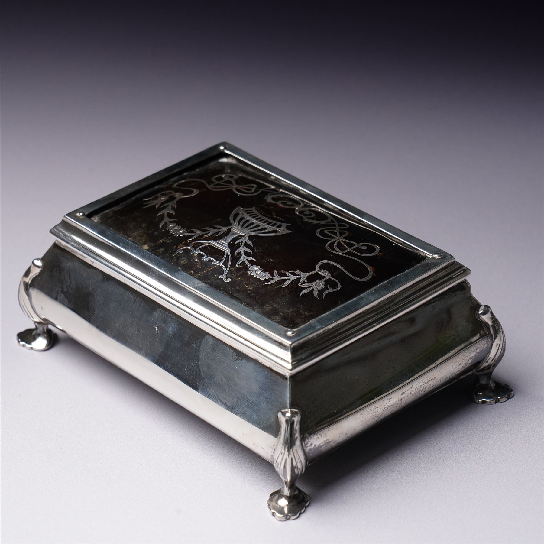 Edwardian silver rectangular trinket box with padded interior, the hinged cover inset with a tortoiseshell panel with pique decoration and on shaped supports W12cm Birmingham 1910 Maker Henry Matthews