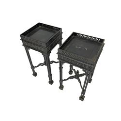 Pair early 20th century black lacquered urn stands, square top with fretwork gallery, on cluster column supports joined by shaped fretwork x-framed stretchers with turned finial, on block feet 