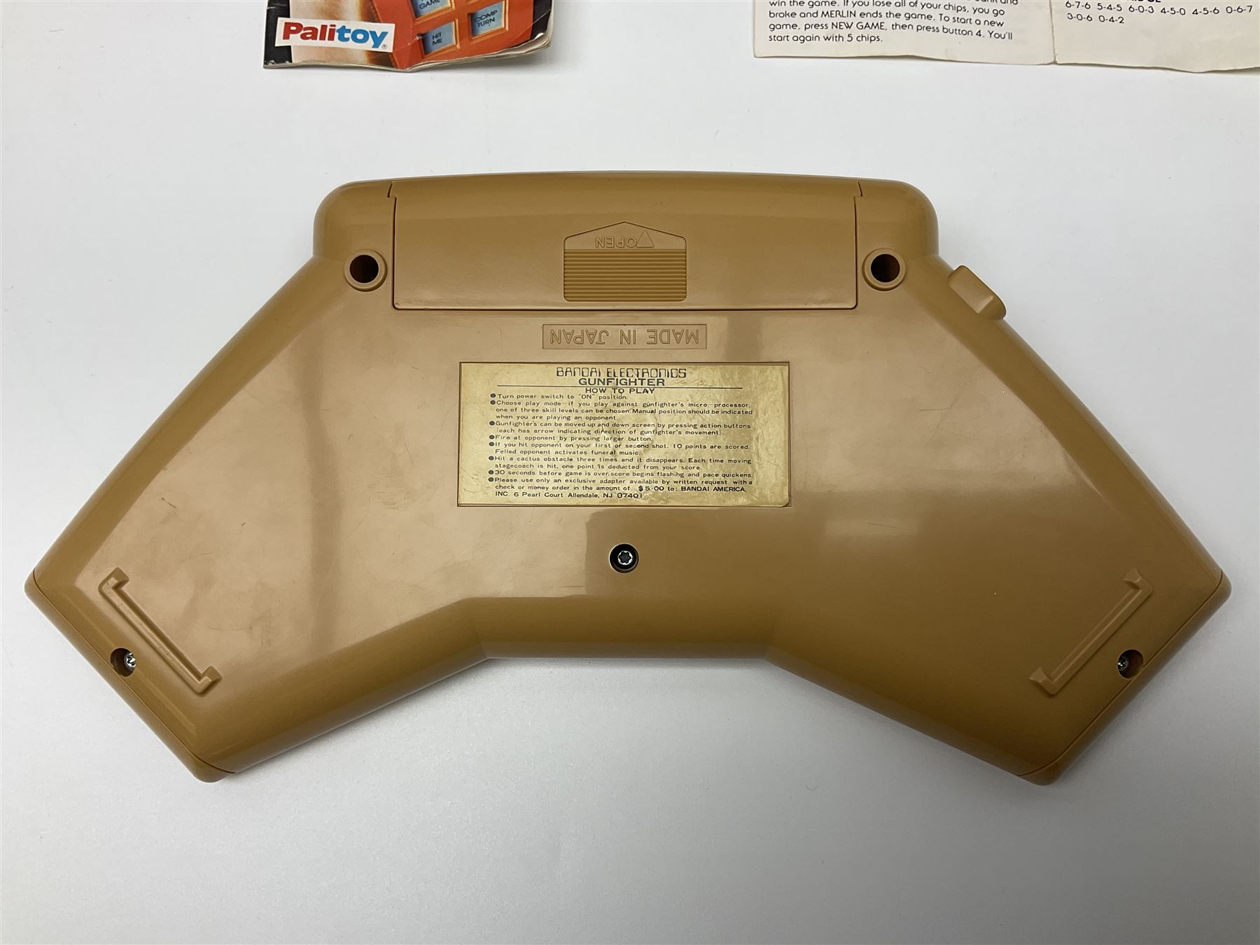 Three late 70s/early 80s handheld electronic games; Bandai Electronics Arcade ‘Gunfighter’ (1980), Grandstand ‘Invader From Space’ (1980), Palitoy ‘Merlin The Electronic Game Machine’ (1979) with game sheet and instruction booklet, all with original boxes (3) 