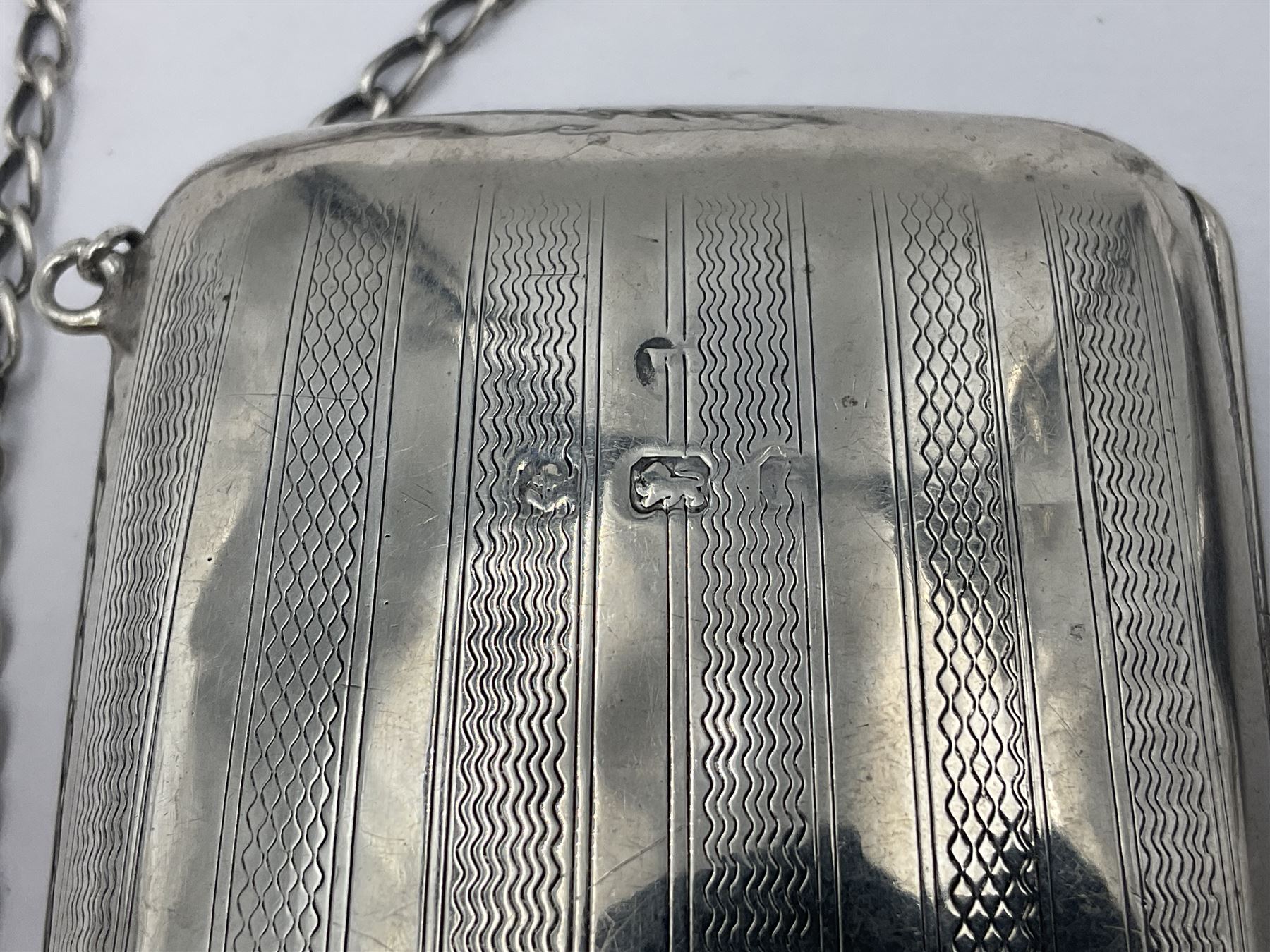 Early 20th century silver mounted coin purse, with leather interior and finger chain, hallmarked Samuel M Levi, Birmingham 1917, together with a similar Edwardian example, with engraved initials and engine turned decoration, hallmarked Birmingham 1907, maker's mark worn and indistinct, largest W11.3cm