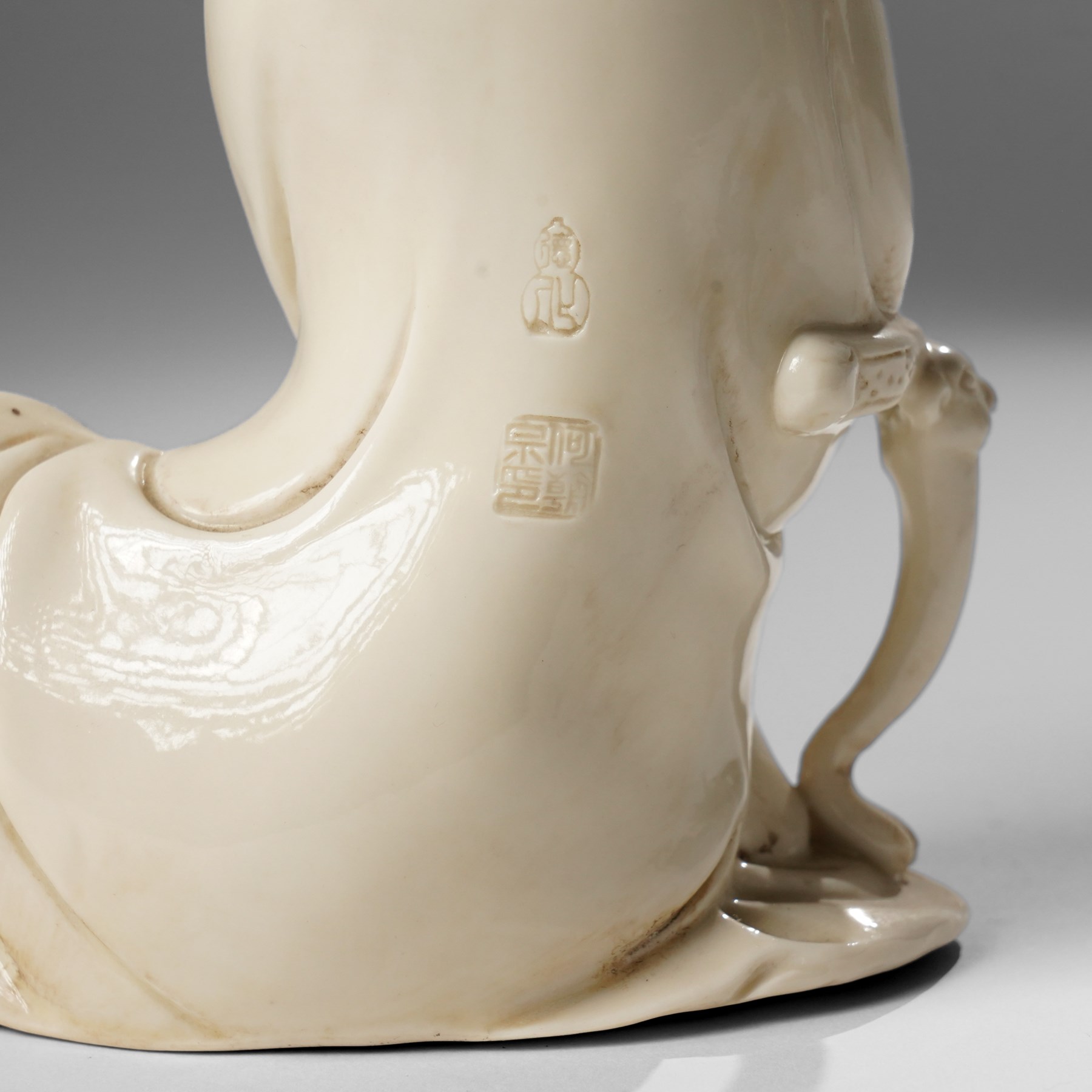 Three Chinese blanc de chine figures, each depicting Guanyin seated, Dehua province, two with double gourd and potters seal marks to the reverse 